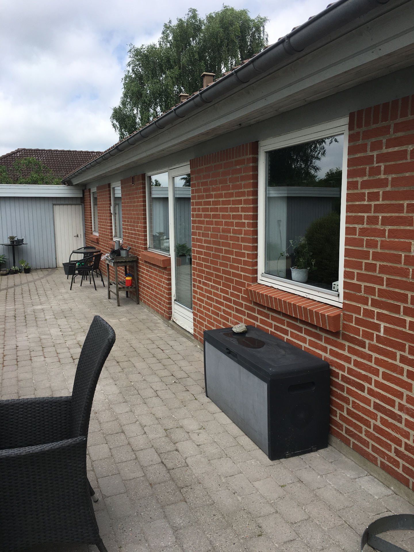 Terrasse med rødt murværk og store vinduer